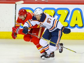 The Calgary Flames’ Mark Giordano gets in a foot race with the Edmonton OIlers’ Connor McDavid at the Saddledome in Calgary on Friday, Feb. 19, 2021.