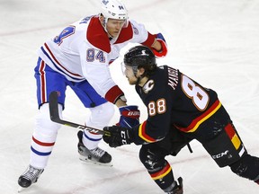 Calgary Flames forward Andrew Mangiapane battles Montreal Canadiens counterpart Corey Perry during a game at the Saddledome in this photo from March 11.