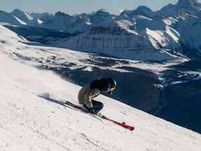 A skier makes makes a turn with Mount Assiniboine in the background at Banff’s Sunshine Village.