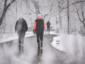 Walkers spend the morning on the Bow River pathway along Memorial Drive N.W. as flurries fall in Calgary on Sunday, April 18, 2021.