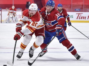 MONTREAL, QC - APRIL 14:  Nick Suzuki #14 of the Montreal Canadiens challenges Joakim Nordstrom #20 of the Calgary Flames during the third period at the Bell Centre on April 14, 2021 in Montreal, Canada.  The Flames defeated the Canadiens 4-1.
