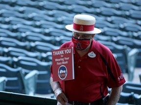 An usher holds a sign that reads, "Thank You for Wearing Your Face Mask" before the game between the Los Angeles Angels and the Chicago White Sox at Angel Stadium of Anaheim earlier this month.