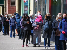 Calgarians line up as they wait to get immunized at the large COVID-19 vaccination site at the Telus Convention Centre on Monday, April 12, 2021.