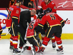 Calgary Flames defenseman Noah Hanifin is helped off the ice after a collision during NHL action against the Montreal Canadiens on Saturday, April 24, 2021. The Flames later announced Hanifin was out for the season with a shoulder injury.

Gavin Young/Postmedia