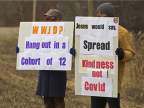 Two people protest outside GraceLife Church's in-person Easter Sunday Service, in Edmonton Sunday April 4, 2021. The church continues to defy COVID-19 public health orders and restrictions.