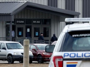 The RCMP watch as parishioners arrive for Easter Sunday Service at GraceLife Church, in Edmonton Sunday April 4, 2021. The church continues to defy COVID-19 public health orders and restrictions.