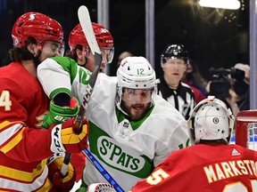 Toronto Maple Leafs' Alex Galchenyuk (12) battles with Calgary Flames' Rasmus Andersson (4) as Flames goaltender Jacob Markstrom (25) looks on during third period NHL action in Toronto on Friday, March 19, 2021.