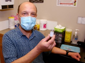 Pharmacist Jason Kmet holds a dose of AstraZeneca vaccine at the Polaris Travel Clinic and Pharmacy in Airdrie. Friday, April 9, 2021. Brendan Miller/Postmedia