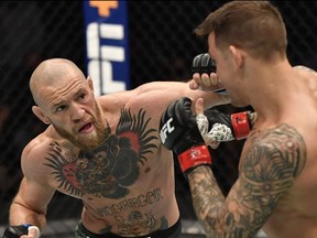 Jan 23, 2021; Abu Dhabi, United Arab Emirates; Conor McGregor of Ireland punches Dustin Poirier in a lightweight fight during the UFC 257 event inside Etihad Arena on UFC Fight Island.