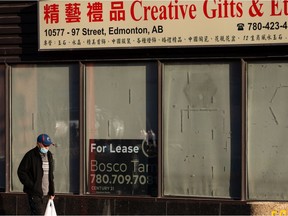 A walker wearing a COVID-19 face mask passes the closed Creative Gifts & Etc. store on 97 Street near 106 Avenue in Edmonton on Friday, Dec. 4, 2020.