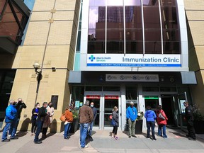 Calgarians line up as they wait to get immunized at the large COVID-19 vaccination site at the Telus Convention Centre on Monday, April 12, 2021.