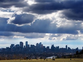 Storm clouds move in over walkers in Edworthy Park and the downtown Calgary skyline on Tuesday, May 4, 2021.