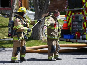 Calgary firefighters clean up after a fire in a duplex in Ranchlands on Wednesday, May 12, 2021.