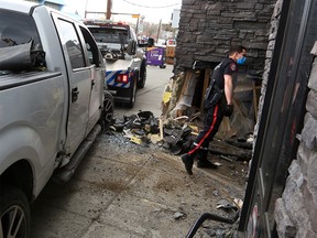 A pickup truck is extricated from a wall on The Pint Public House on 17th Avenue S.W. on Thursday, May 13, 2021. A driver and passenger fled the scene after the collision.