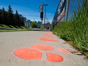 Footprints are painted on the sidewalk across from Langevin School and signs were placed on fences calling for the school name to be changed on Monday, May 31, 2021. Calls are growing for the school to be renamed immediately following the discovery of a mass grave of children at a former residential school in Kamloops. The school was named after Hector-Louis Langevin who was the “architect” of the residential schools in Canada.