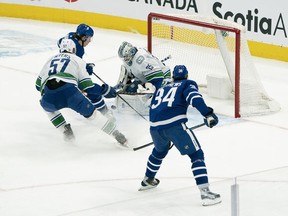 Maple Leafs forward Mitch Marner (16) is stopped by Canucks goaltender Thatcher Demko on Saturday night in Vancouver.