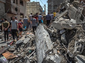 Palestinians inspect damage to buildings in Gaza City on May 20, 2021.