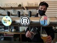 A staff member pours beer at La Fourmiliere bar while Belgium reopens their outdoor space, including the terraces of the bars and restaurants, after closing down for months amid amid the coronavirus disease (COVID-19) outbreak in Brussels, Belgium May 8, 2021.