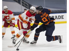 Edmonton Oilers superstar Connor McDavid (right) scores on Chris Tanev and the Calgary Flames as he rifles home a puck during first-period NHL action on Saturday, May 1, 2021, in Edmonton. Greg Southam/Postmedia