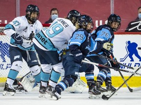 Team Bauer’s Marie-Philip Poulin (29) and Karell Emard (76), and Team Sonnet’s Brianne Jenner (19) and Jamie Lee Rattray (47) battle for position during the PWHPA Secret Dream Gap Tour Calgary tournament final at the Saddledome on Sunday, May 30, 2021.