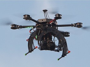 FILE - RCMP use a camera mounted drone as they investigate at the scene of a single vehicle accident along the Queen Elizabeth II Highway, north of Panoka Alta., on Monday Sept. 22, 2014. A plan from the province to use drones to monitor campers has been scrapped after a public outcry.