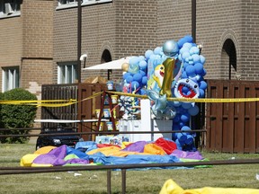 A balloon birthday display for a one-year-old is part of the crime scene with evidence markers and blood on the ground as Toronto Police sift through the area where a multi-victim shooting occurred at a double birthday celebration at a housing complex on Tandridge Cres. off of Albion Rd. at 8 p.m. Saturday.
