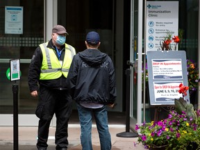 A client checks in at the entrance to the Telus Convention Centre COVID-19 vaccination clinic on Thursday, June 10, 2021.