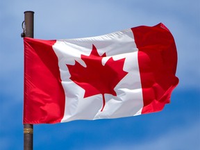 A Canadian flag flies above the Big Four building at the Calgary Stampede grounds on Thursday, June 17, 2021.