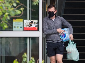 Calgarians exit the downtown Real Canadian Superstore on Sunday, June 20, 2021. Council will be looking at when to lift the current mandatory mask bylaw this summer.