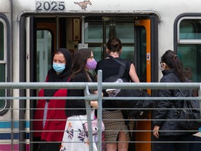 Riders wear masks while riding the CTrain on Wednesday, June 23, 2021. Mandatory masking for transit and taxis will remain when most provincial pandemic restrictions are lifted on July 1.
