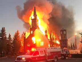 A fire burns a Catholic church as shown in this handout image provided by Tracy Dalzell-Heise in Morinville, Alberta on Wednesday, June 30, 2021. The church has been destroyed by what RCMP are calling a suspicious fire. RCMP say in a release that officers were called to the blaze at St. John Baptiste Parish in Morinville, about 40 kilometres north of Edmonton, just after 3 a.m.