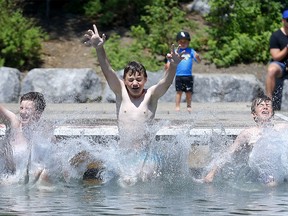 Friends L-R, Kyler Brown, 12, Grady Larson, 12, and Spencer Banks, 13, cool down at the lagoon at Bowness Park as temperatures soared in Calgary on Tuesday, June 29, 2021.