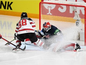 Canada's forward Andrew Mangiapane (C) scores past US' goalkeeper Calvin Petersen (R) during the IIHF Men's Ice Hockey World Championships semi-final match between the USA and Canada at the Arena Riga in Riga, Latvia, on June 5, 2021.