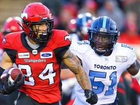Calgary Stampeders Reggie Begelton takes off with the ball under pressure from Micah Awe of the Toronto Argonauts during CFL football in Calgary on Thursday, July 18, 2019. Al Charest/Postmedia