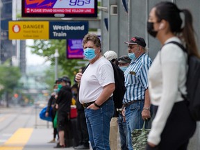 People wait for a CTrain in downtown Calgary on Sunday, June 20, 2021.