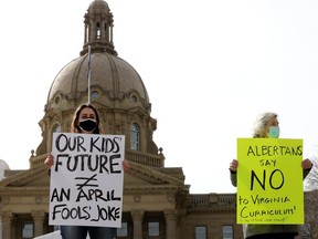 Gillian Robinson, left, and Maureen Towns protest the province's draft K-6 curriculum outside the Alberta legislature in Edmonton on April 1, 2021.