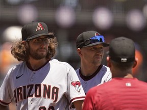 Arizona Diamondbacks starting pitcher Zac Gallen (23) stands on the mound before being removed by manager Torey Lovullo, right, in the third inning of a baseball game against the San Francisco Giants on Thursday  in San Francisco.