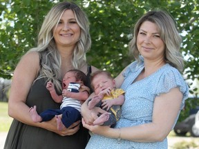 Sisters Liz Connolly and Alyssa Wiehe poses for a photo with newborns Tate and Wyatt. The pair of sisters ended up delivering both babies within hours of one another.