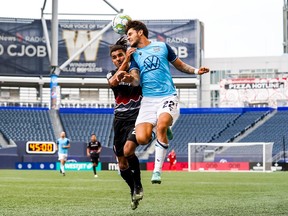 Cavalry FC's Mohamed Farsi and HFX Wanderers FC's João Morelli battle for the ball.