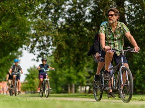 Cyclists ride on the pathway along the Memorial Drive N.W. on a warm summer afternoon on Tuesday, July 27, 2021.