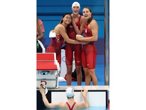 Rebecca Smith stands tall in the middle of the group hug after Canada's women's 4x100-metre freestyle relay team won silver in the pool late Saturday in Tokyo at the Olympic Games.