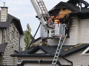 Investigators probe the scene of a house fire on Oakmere Close in Chestermere, AB east of Calgary on Friday, July 2, 2021. Jim Wells/Postmedia