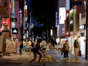 A woman skateboards on a shopping street amid tightened social distancing rules due to the COVID-19 pandemic in Seoul, South Korea, July 12, 2021.
