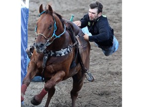 Team Marc Andra Potvin and Maxime Clermont compete in a horse exchange where cowboys attempt to switch horses their riding on race at the Calgary Stampede's Broncs After Dark rodeo event.