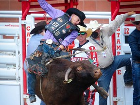 Cody Coverchuk, of Meadow Lake, Sask., hangs on tight for an 84.50 onRed Jam during the bull-riding event at the Calgary Stampede rodeo on Friday, July 9, 2021.