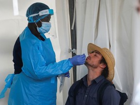 A man gets a COVID-19 test before being allowed entry into Nashville North a live concert venue as the Calgary Stampede gets underway following a year off due to the coronavirus disease (COVID-19) restrictions, in Calgary, Alberta, Canada July 9, 2021.