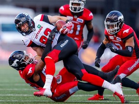 The Calgary Stampeders’ Jameer Thurman tackles the Ottawa Redblacks’ Greg Ellingson during a game at McMahon Stadium in Calgary on June 28, 2018.