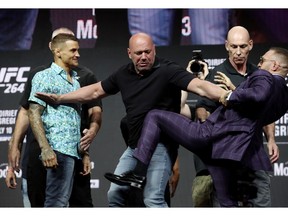 Conor McGregor throws a kick to Dustin Poirier during a press conference with Dana White prior to UFC 264.
