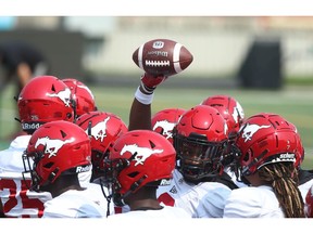 Stampeders players hoist the ball in a group during practice at McMahon Stadium in Calgary on Saturday, July 24, 2021. Jim Wells/Postmedia