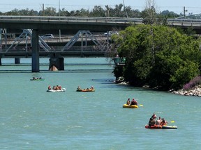 People enjoy a hot Canada Day afternoon by floating on the Bow River.